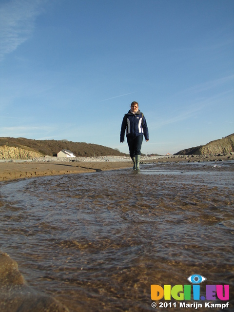 SX17199 Jenni walking through stream on Llantwit Major beach